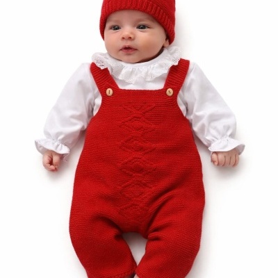 Bebé com fato vermelho de malha e chapéu com pompom branco