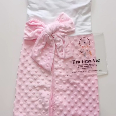 Manta rosa com textura bolinhas e laço, parte superior branca e cartão com texto Era Uma Vez.