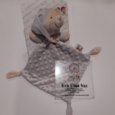 Manta de tecido cinza com relevo e cabeça de ursinho de pelúcia