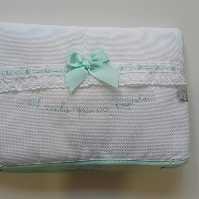 Manta branca texturada com renda, fita verde clara e bordado em verde claro