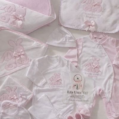 Conjunto de roupa e acessórios de bebé brancos e rosa com bordados de coelhos e laços