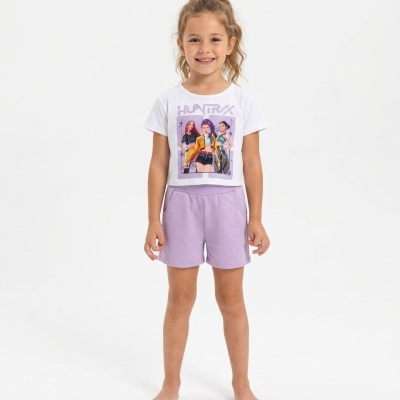 Menina com t-shirt branca estampada e calções lilás em fundo branco