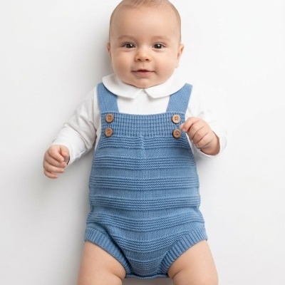 Bebé com roupa azul e branca a sorrir