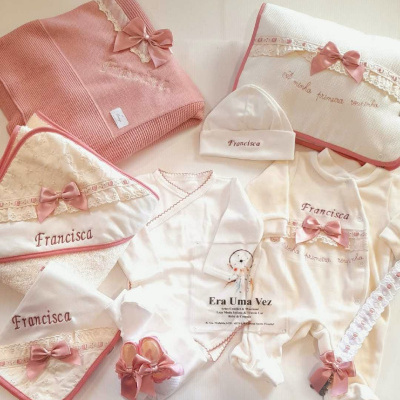Conjunto de roupas e acessórios de bebé branco e rosa com bordados e laços