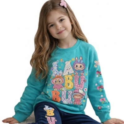 Menina com conjunto infantil azul turquesa e azul escuro com estampados de personagens e letras coloridas