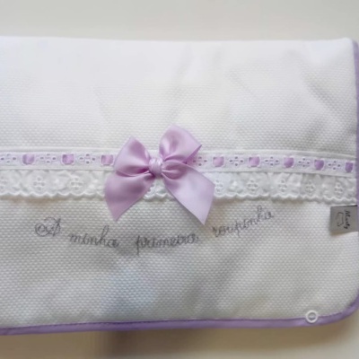 Manta branca com renda e laço lilás, texto bordado e etiqueta Nina