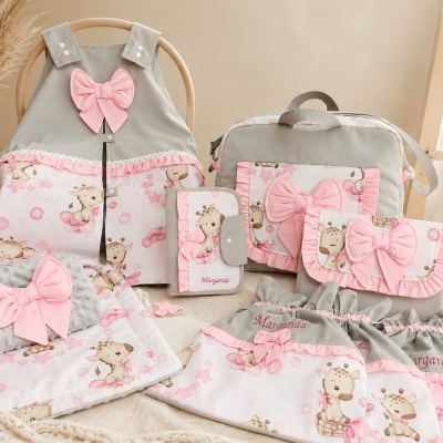 Conjunto de artigos para bebé com tecido cinzento, branco e rosa e laços cor-de-rosa