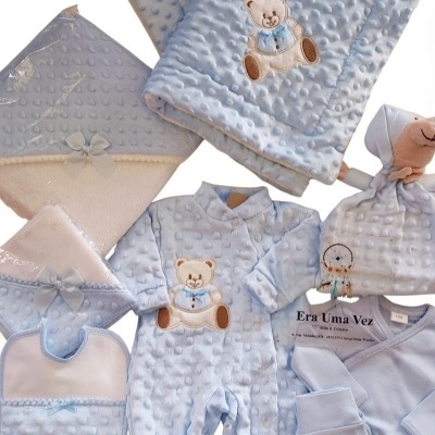 Conjunto de roupa de bebé azul claro com ursinho bordado e textura bolha.