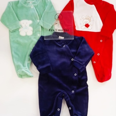 Três macacões de bebé em veludo, verde, vermelho e azul com bordados.