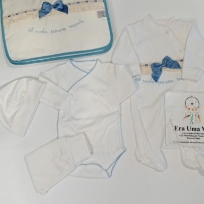 Conjunto roupa bebé branco com detalhes em azul e laço azul.