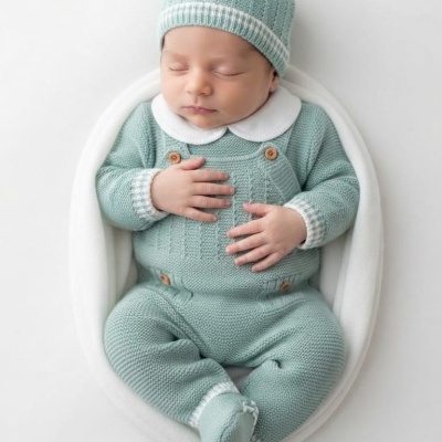 Bebé vestido com conjunto de malha verde-água com detalhes brancos a dormir