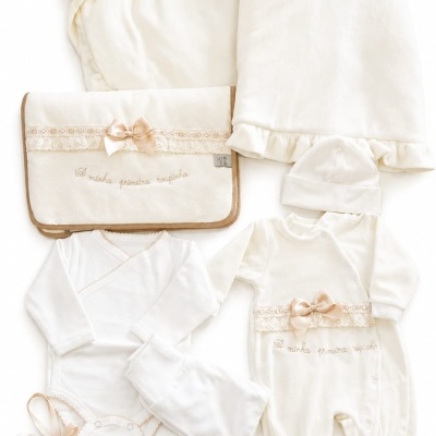 Conjunto de roupa de bebé creme com detalhes em renda e laço bege, manta, bolsa com inscrição bordada e almofada coração