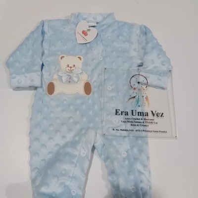 Pijama de bebé azul claro com aplicação de ursinho e placa transparente com texto da loja Era Uma Vez