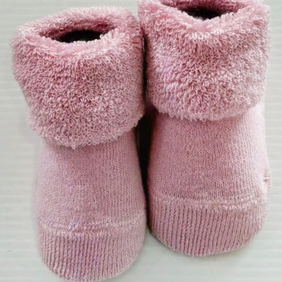Meias cor-de-rosa para bebé com parte superior felpuda em fundo branco.