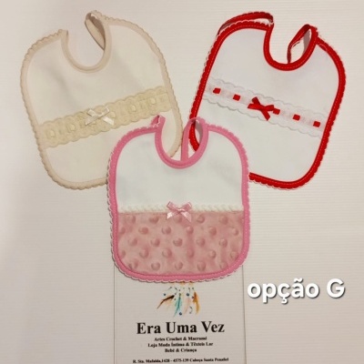 Três babetes de cores bege, vermelho e rosa com laços e decoração, sobre fundo branco com etiqueta Era Uma Vez