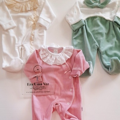 Três macacões de bebé em branco, verde e rosa com detalhes em renda e botões
