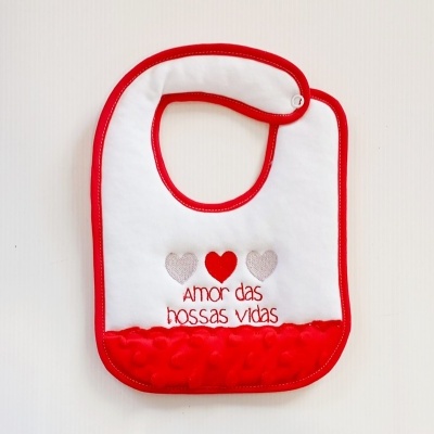 Babete branco com bordas vermelhas e texto bordado