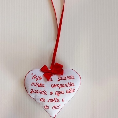 Almofada em formato de coração branco com bordado vermelho e fita vermelha para pendurar