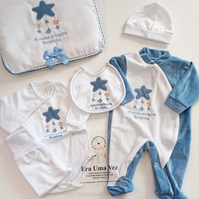 Conjunto de roupas de bebé azul e branco com estrelas e texto bordado.