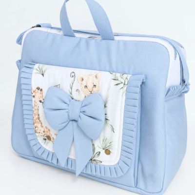 Mala azul clara com bolso frontal decorado com franjas e laço grande