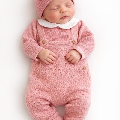 Bebé a dormir vestido com roupa de malha rosa
