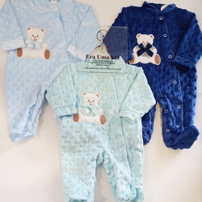 Macacões de bebé felpudos em azul claro, verde água e azul escuro com ursinhos bordados.