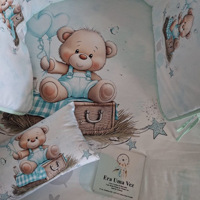 Cama-de-bebé com padrão de ursinhos castanhos e elementos azuis.