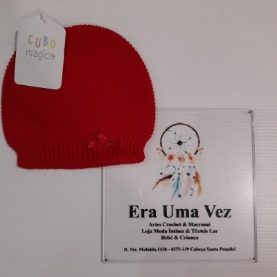 Gorro vermelho de malha com etiqueta 'CUBO mágico' junto a cartão promocional de loja Era Uma Vez