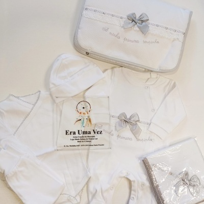 Conjunto de roupa branca para bebé com detalhes cinzentos e embalagem com laço