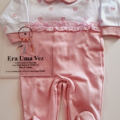 Pijama de bebé rosa e branco com padrão de ursinhos e folhos, sobre superfície branca
