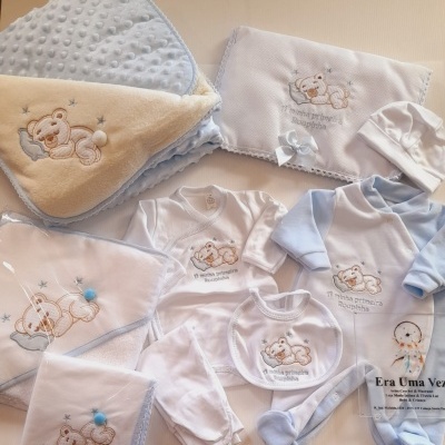 Conjunto de roupa e acessórios de bebé com ursinho bordado e texto em português