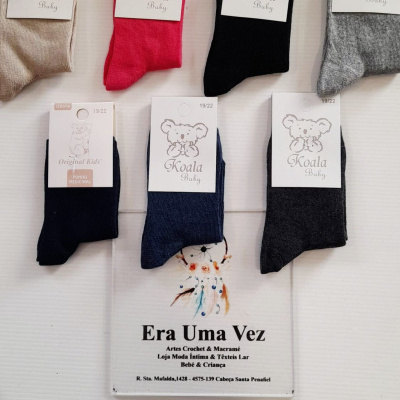 Meias de bebé coloridas com etiquetas Koala Baby e Original Kids em fundo branco.
