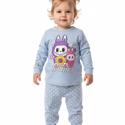 Criança com pijama azul claro com estampado colorido e calças com bolinhas brancas.