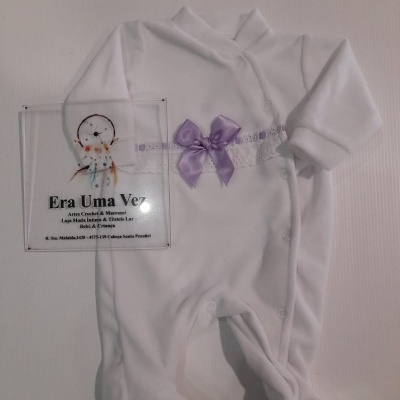 Pijama de bebé branco com laço roxo e placa com texto da loja