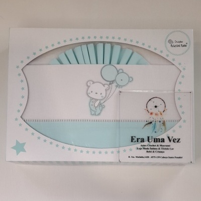 Caixa branca com roupa de bebé azul e desenho ursinho