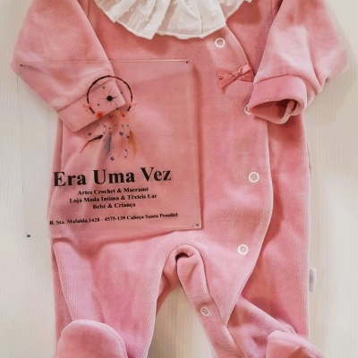 Pijama rosa para bebé com folho branco e texto promocional ao lado