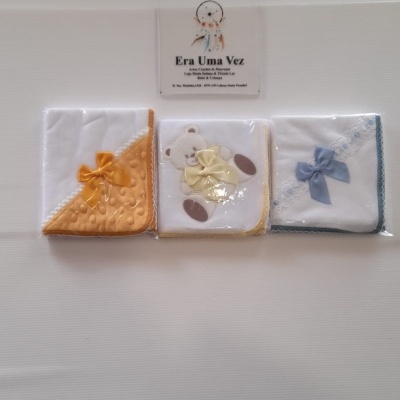 Três toalhinhas de bebé embaladas com laços coloridos e ursinho bordado