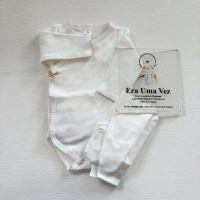 Body de bebé branco com detalhes castanhos claro e placa transparente com texto de loja