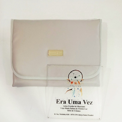 Bolsa bege claro com placa dourada e cartão transparente com apanhador de sonhos e texto informativo