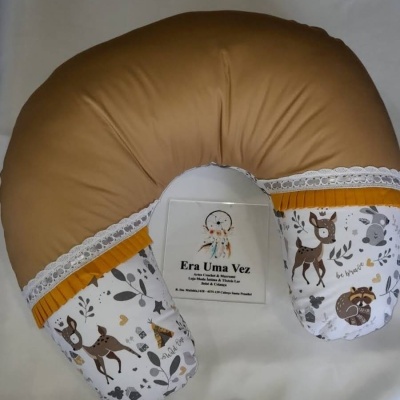 Almofada em forma de U com tecidos castanho e estampado de animais, renda branca e fita amarela