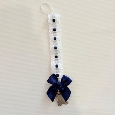 Prendedor de chupeta com fita branca e azul e clip metálico com ursinho.