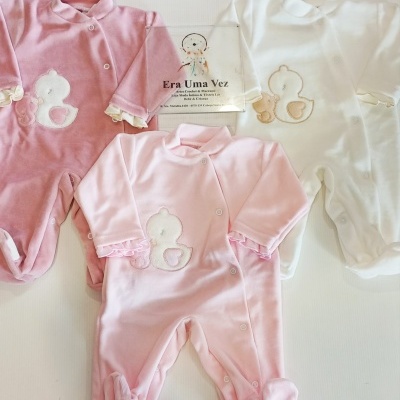 Três macacões de bebê rosa forte, rosa claro e branco em veludo, com bordado de pato e folhos nas mangas.