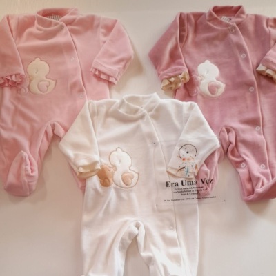 Três pijamas de bebé em veludo rosa e branco com motivos de pato e ursinho, texto visível Era Uma Vez