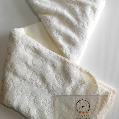 Manta branca felpuda com padrões em relevo e cartão informativo da loja Era Uma Vez