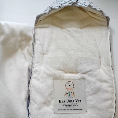 Porta-bebé branco com capuz cinza e etiqueta de marca