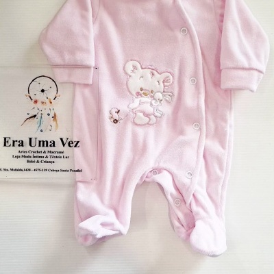 Pijama de bebé rosa com bordado de ursinho e texto publicitário ao lado