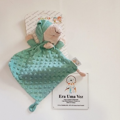 Manta de apego verde com ursinho de peluche em embalagem com etiquetas Gambertitos