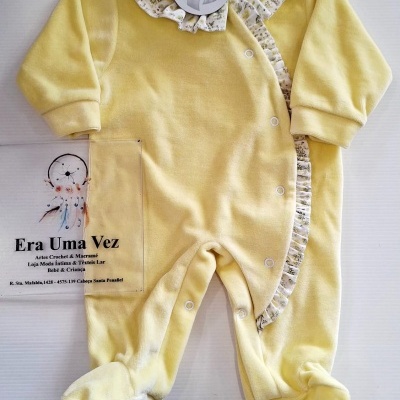 Macacão de bebé amarelo com gola floral e botões na frente.