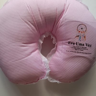 Almofada rosa em formato de U com textura em waffle e etiqueta com texto e filtro dos sonhos.