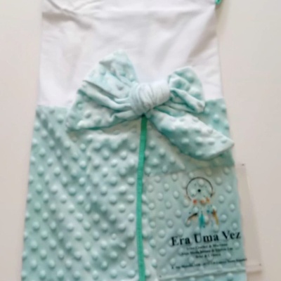 Manta de bebé branca e azul claro com textura bolinhas e laço azul